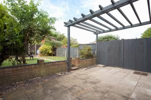 a pergola in a backyard with a fence at Stylish & Spacious 3BR Home With Private Driveway in Bletchley