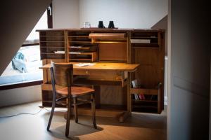 a desk and chair in a room with a book shelf at B&B Moensberg in Brussels