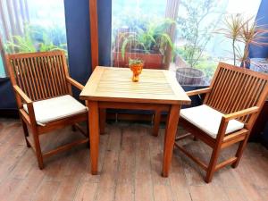 - une table en bois avec 2 chaises et un vase dans l'établissement Beautiful, à Lima