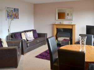 a living room with a couch and a table at Assynt Chalet - Uk30806 in Lochinver