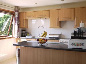 a kitchen with wooden cabinets and a bowl of fruit on the counter at Assynt Chalet - Uk30806 in Lochinver