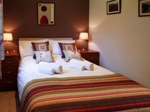 a bedroom with a large white bed with pillows at Assynt Chalet - Uk30806 in Lochinver