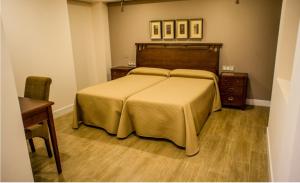 1 dormitorio con 1 cama grande y suelo de madera en Apartamentos Rondacentro en Ronda