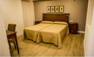 a bedroom with a large bed and a wooden floor at Apartamentos Rondacentro in Ronda