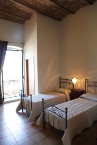 a bedroom with two beds and a large window at I Due Principi in San Marco Argentano