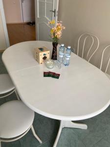 a white table with bottles of water and flowers on it at Апартаменты в центре города in Astana