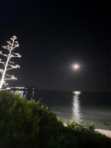 a full moon over the water at night at CENTRAL ROOMS TORTOLI' in Tortolì