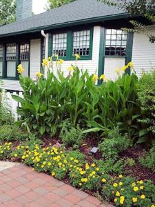 a garden of flowers in front of a house at Granbury Gardens Bed and Breakfast in Granbury