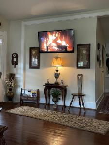 a living room with a fire on the wall at Granbury Gardens Bed and Breakfast in Granbury