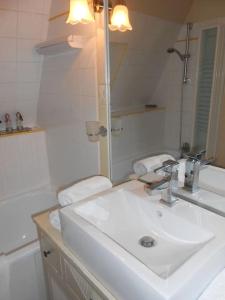 a white bathroom with a sink and a mirror at Cité médiévale, charme & calme, bien placé in Sarlat-la-Canéda
