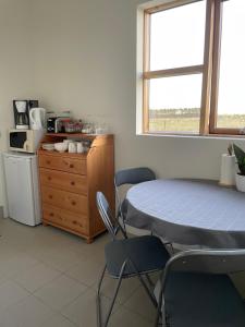 a room with a table and chairs and a kitchen at Halakot guesthouse in Laugardælir +7 photos
