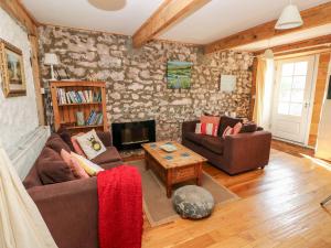 ein Wohnzimmer mit zwei Sofas und einem Tisch in der Unterkunft Beekeeper's Cottage in Lamphey