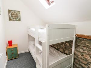 LampheyにあるBeekeeper's Cottageの白い二段ベッドが備わる客室です。