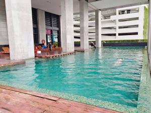 een persoon die zwemt in een zwembad in een gebouw bij Arcoris Suite 1-4 Pax ThePrince HighFloor/Balcony in Kuala Lumpur