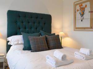um quarto com uma cama grande e toalhas em Secret View Cottage em Terrington