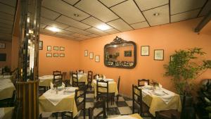 una sala da pranzo con tavoli, sedie e specchio di Hotel Sirius a Funchal
