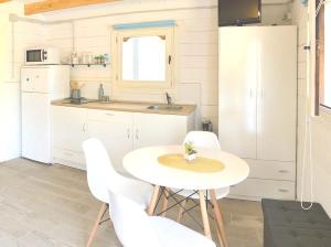 uma cozinha com uma mesa branca e cadeiras brancas em Chiclana-Cabaña-Parking-BLUE em Chiclana de la Frontera