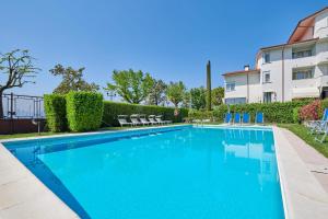 a swimming pool in front of a building at Front Lake Apartment Rainer in Bardolino