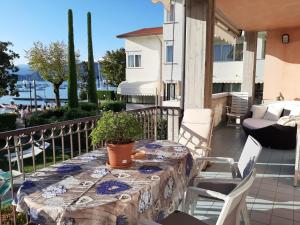 a patio with a table and chairs on a balcony at Front Lake Apartment Rainer in Bardolino
