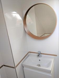 a bathroom with a sink and a mirror on the wall at Marica Apartman in Balatonfenyves