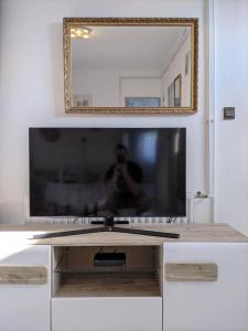 バラトンフェニヴェシュにあるMarica Apartmanの白いキャビネットの上に座る薄型テレビ