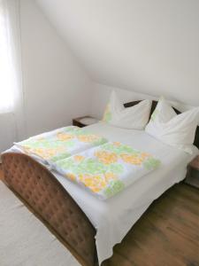 a bed with a comforter and pillows on it at Marica Apartman in Balatonfenyves