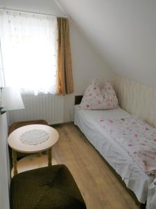 a small bedroom with a bed and a table at Marica Apartman in Balatonfenyves