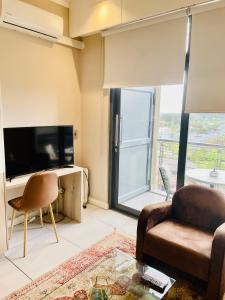 uma sala de estar com um sofá e uma televisão em Menlyn Maine Trilogy Hotel em Pretoria