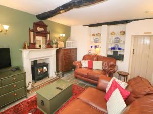 a living room with a couch and a fireplace at Clematis Cottage in Bakewell