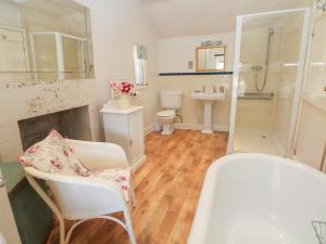 a bathroom with a tub and a toilet and a sink at Clematis Cottage in Bakewell +11 photos