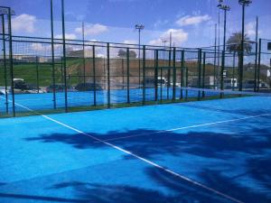 una pista de tenis con una pista de tenis azul en Hotel Castillo de Montemayor, en Montemayor