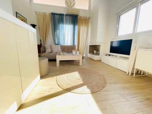 un soggiorno con divano e TV di Syllas Grand Resort - Executive View Villa 1 a Edipsos