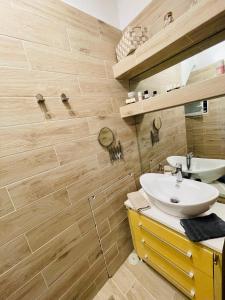 a bathroom with a white sink and wooden walls at Syllas Grand Resort - Executive View Villa 1 in Edipsos