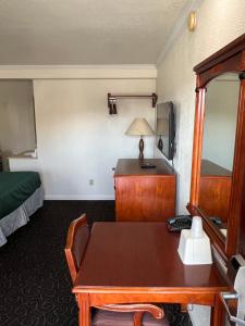 ハンフォードにあるAmericas Best Value Inn Hanfordのテーブルとベッドが備わるホテルルームです。