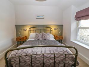 1 dormitorio con 1 cama con 2 mesitas de noche en Y Castell Apartment 3 en Porthmadog