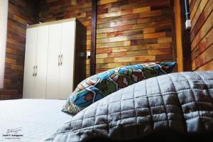 a bedroom with a bed and a wooden wall at Nossacasa-de-campo in Blumenau