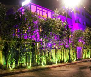 a building with purple lights in front of a fence at Majorel Pearl Hotel-Riad-Restaurant Piscine&Spa in Marrakesh