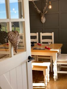 comedor con mesa de madera y sillas en Kinnoull House near Stornoway Hot Tub/Pet Friendly en Garrabost