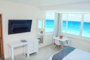 a bedroom with a bed and a desk and a window at Frente al mar, increíble vista, nuevo estudio 1 C in Cancún