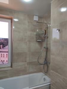 a bathroom with a shower and a bath tub at Pushkin street Pearl in Kutaisi