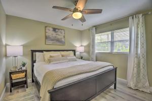 a bedroom with a bed with a ceiling fan and a window at Cozy Sarasota Retreat - 3 Blocks to the Coast! in Sarasota