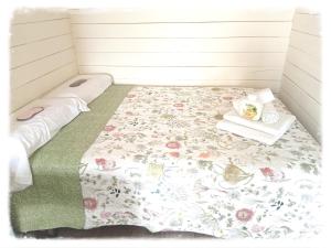 a small room with a bed with a floral bedspread at AGUA Cabaña con jardín y parking privado Chiclana in Chiclana de la Frontera