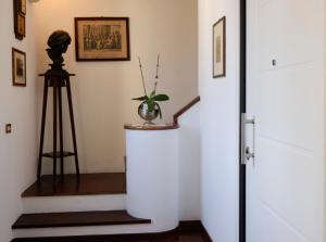a hallway with a staircase with a vase and a tripod at Attico con terrazza sul porto in Palermo