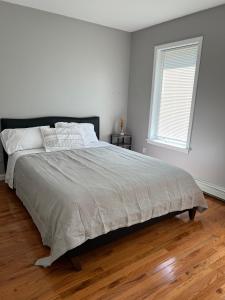a white bedroom with a large bed and a window at Comfy Loft Beacon NY in Beacon