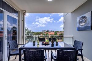 ein Esszimmer mit Tisch und Stühlen auf einem Balkon in der Unterkunft Sunset 16 Caya Dr. J.E.M. Arends 1 in Palm-Eagle Beach
