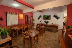 una sala da pranzo con pareti rosse e tavoli e sedie in legno di Pousada Boa Vista a Tiradentes