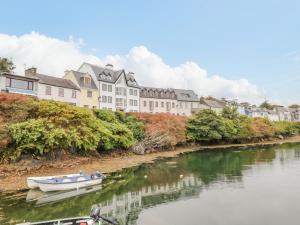 a boat on a river with buildings in the background at Sea Watch House in Roundstone