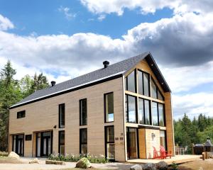 un gran edificio con ventanas laterales en Le Baluchon Éco-villégiature, en Saint-Paulin