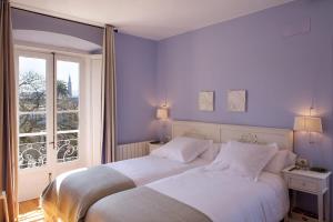 a bedroom with two beds in front of a window at CASONA QUINTA HERMINIA in Gijón