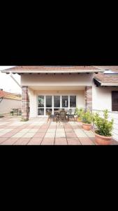 EttendorfCHARMANT T3, 70m2, 2ch,TV 101 cm, WIFI+Parking,的房屋前设有带2张桌子和椅子的庭院。